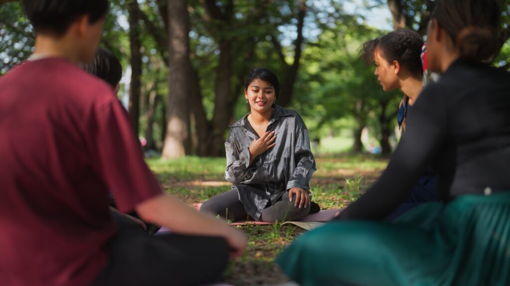 Students sitting outdoors with trees in background