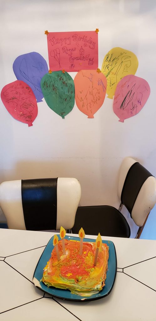 Cake on a table with fake candles and the banner above