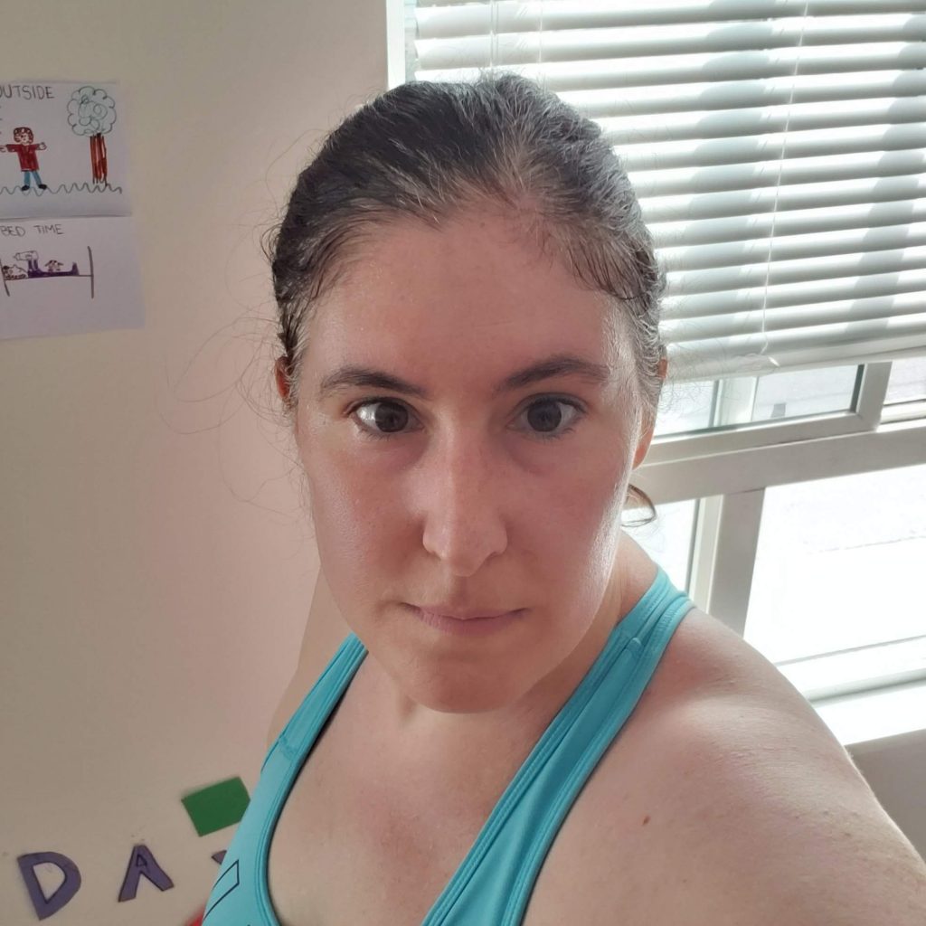 Arley taking a post-workout selfie in a blue sports bra
