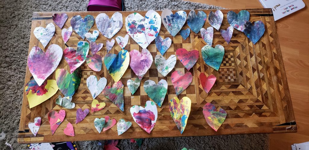 Multi-coloured hearts laid out on a table.
